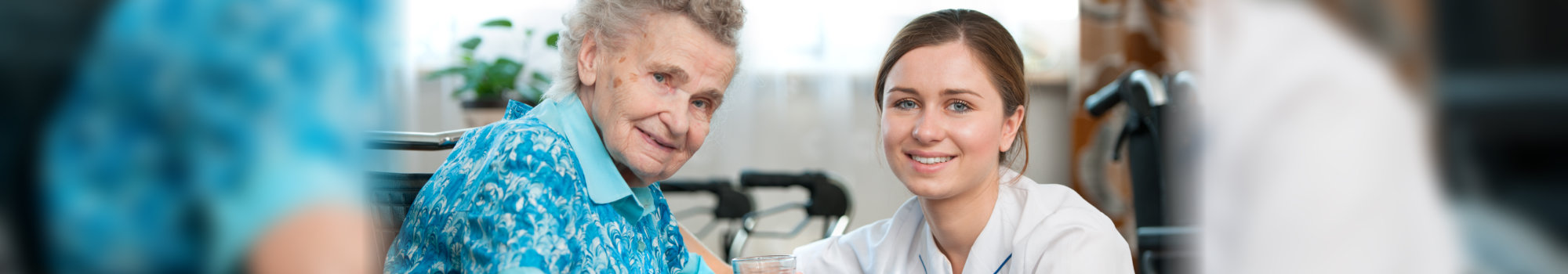elderly woman and her caregiver smiling